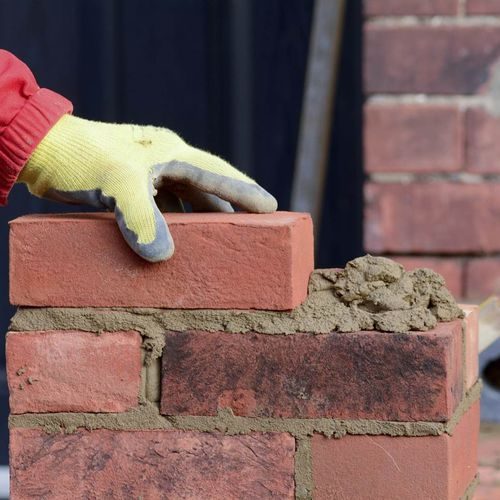 Pekerja konstruksi memasang bata dengan mortar yang menggunakan cellulose ether