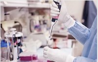Teknisi laboratorium menggunakan pipet dalam pengujian bahan kimia industri
